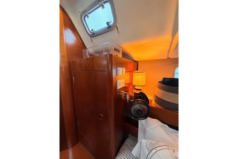Slide: The Image of Cozy cabin interior of 1997 Beneteau Oceanis 351 sailboat with warm lighting and wooden finish. - 44