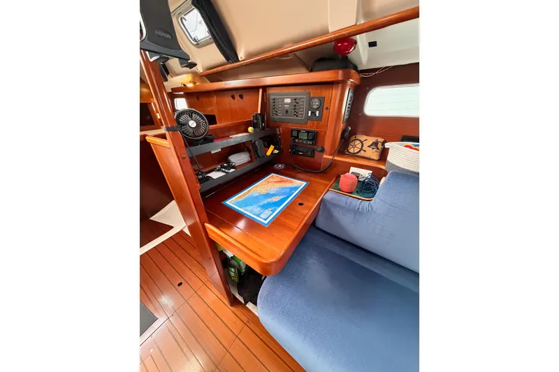 Slide: The Image of Navigation station inside 1997 Beneteau Oceanis 351 sailboat, featuring chart table and control panel. - 46