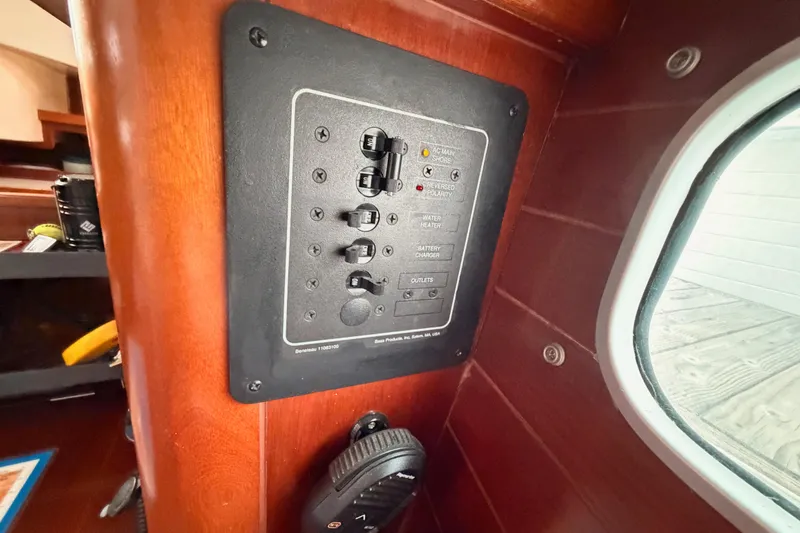 Slide: The Image of Electrical panel inside 1997 Beneteau Oceanis 351 sailboat, featuring switches and controls. - 48
