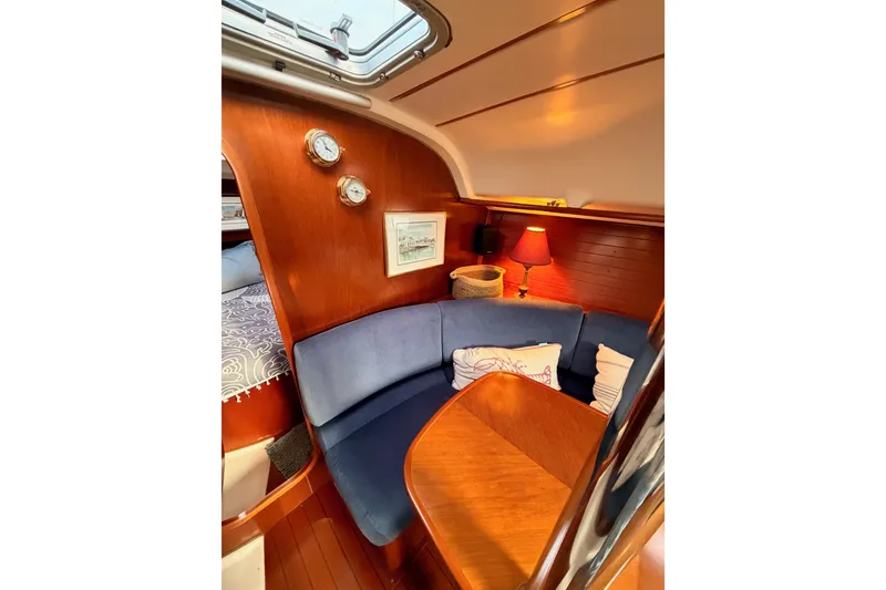 Slide: The Image of Cozy interior of 1997 Beneteau Oceanis 351 sailboat with blue seating and wooden accents. - 52