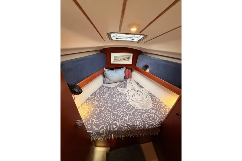 Slide: The Image of Cozy cabin interior of 1997 Beneteau Oceanis 351 sailboat with patterned bedding. - 55