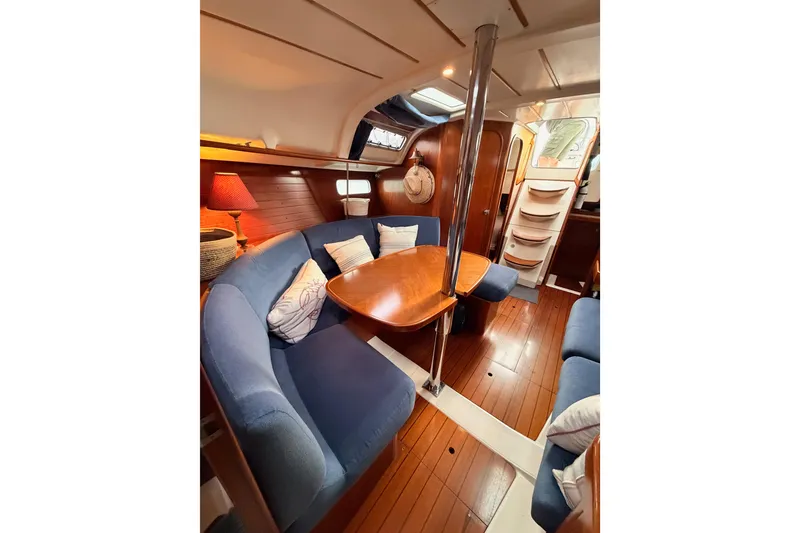 Slide: The Image of Cozy interior of 1997 Beneteau Oceanis 351 sailboat with blue seating and wooden table. - 62