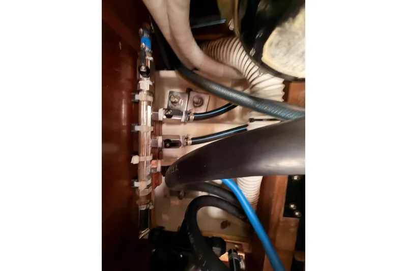 Slide: The Image of Engine compartment of a 1997 Beneteau Oceanis 351 sailboat, showcasing hoses and fittings. - 67