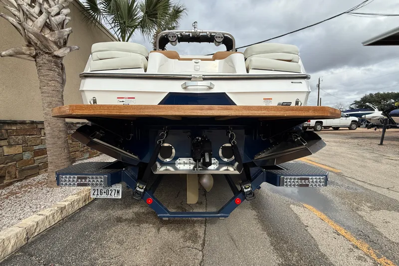 Slide: The Image of 2022 MasterCraft XT24 boat rear view with swim platform and dual exhaust. - 5