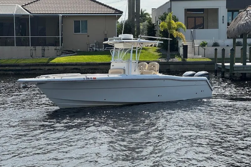 The Image of 2014 Stamas 317 Tarpon boat on a calm waterfront, near modern homes. - 0