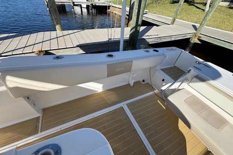 Slide: The Image of 2014 Stamas 317 Tarpon boat interior with cushioned seating and wooden flooring. - 17