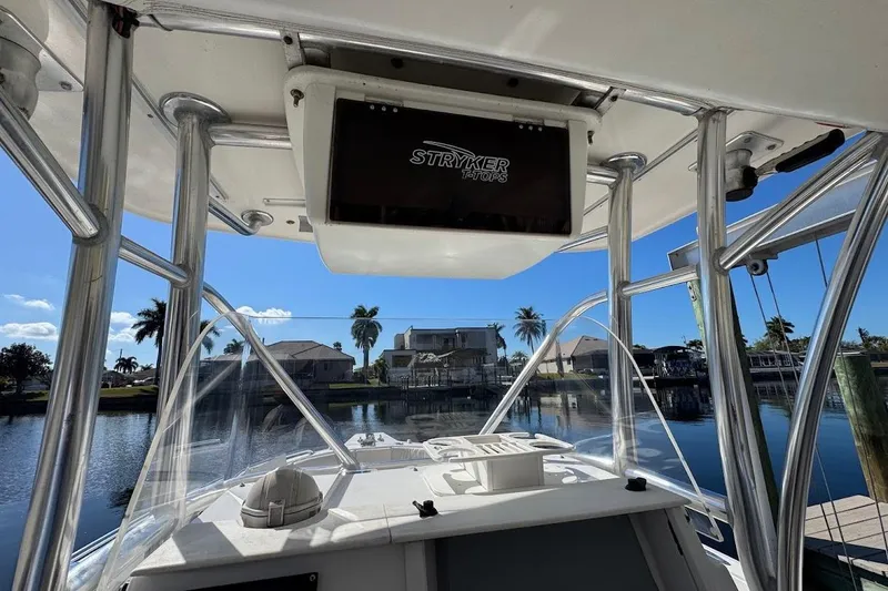 Slide: The Image of 2014 Stamas 317 Tarpon boat with Stryker T-Tops, docked by a scenic waterfront. - 39