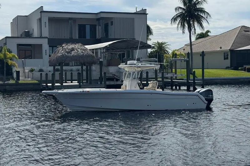 Slide: The Image of 2014 Stamas 317 Tarpon boat on water near modern waterfront homes and palm trees. - 4