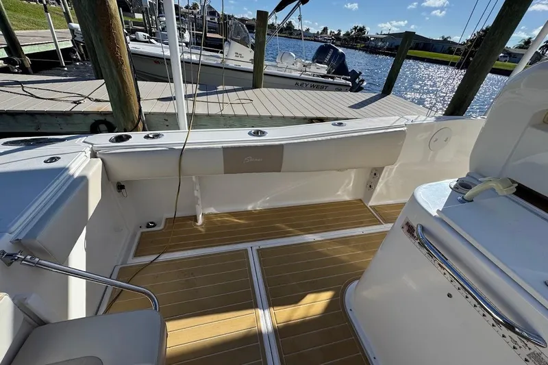 Slide: The Image of 2014 Stamas 317 Tarpon boat interior with wooden deck, docked by the water. - 42
