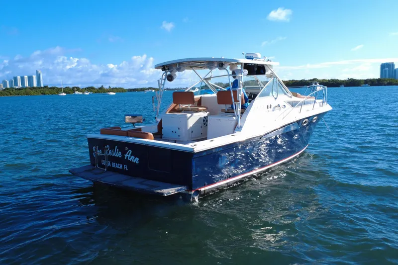Slide: The Image of 1996 Wellcraft 330 Coastal boat on blue water, sunny day, city skyline in background. - 13
