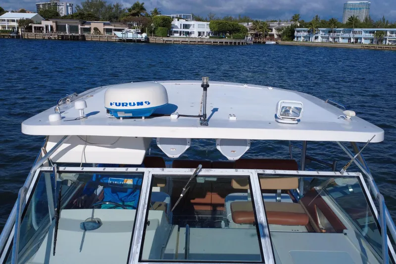 Slide: The Image of 1996 Wellcraft 330 Coastal boat on water, featuring radar equipment and clear skies. - 20