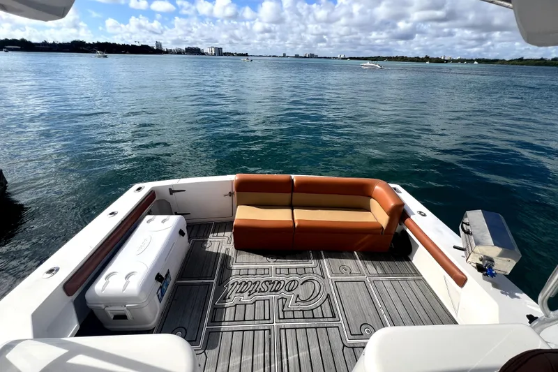 Slide: The Image of 1996 Wellcraft 330 Coastal boat interior with brown seating and custom flooring under blue sky. - 25