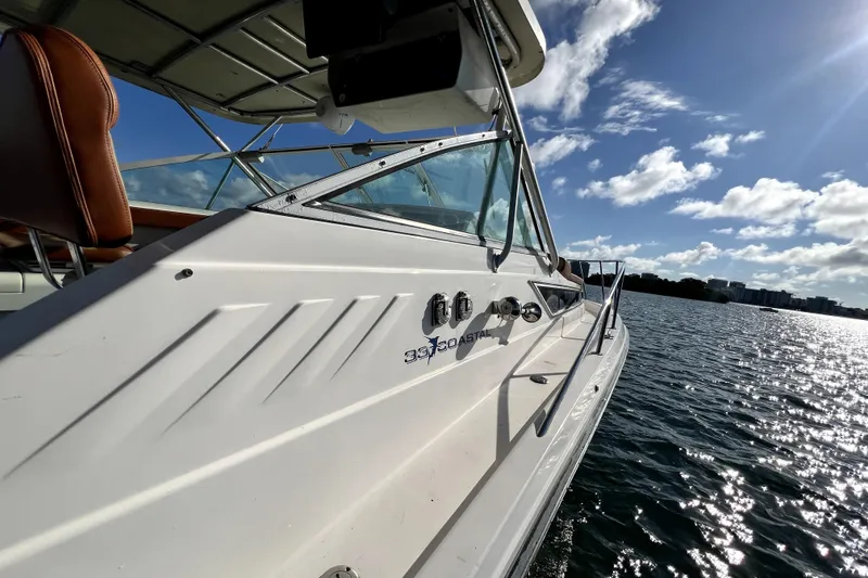 Slide: The Image of 1996 Wellcraft 330 Coastal boat helm with steering wheel, dashboard, and ocean view. - 51