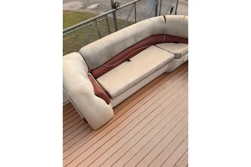 Slide: The Image of 2011 Sun Tracker Party Barge 21 Signature Series with beige and red seating on wooden deck. - 10