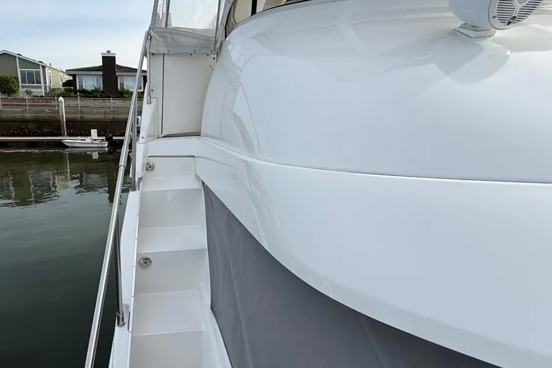 Slide: The Image of 1999 Silverton 392 Motor Yacht side view with dock and water background. - 12