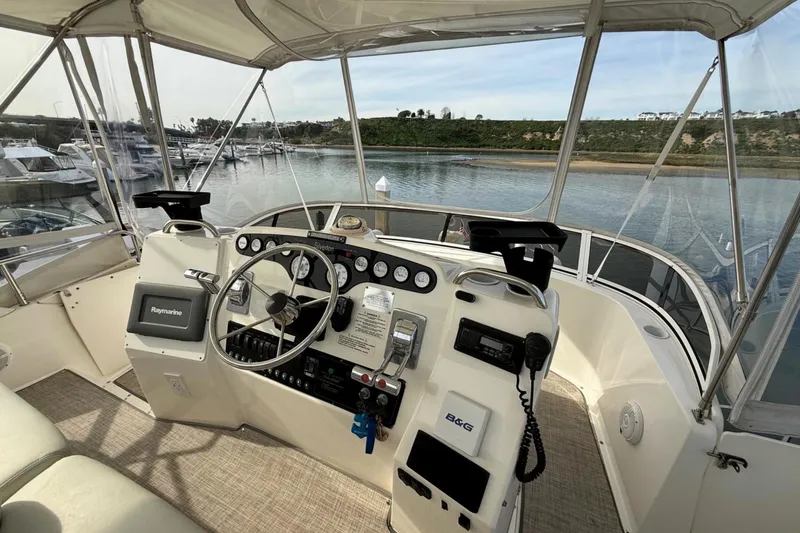 Slide: The Image of 1999 Silverton 392 Motor Yacht helm with navigation equipment, overlooking marina and waterway. - 20