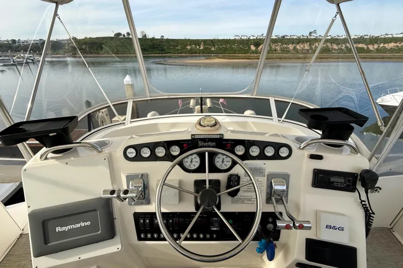 Slide: The Image of 1999 Silverton 392 Motor Yacht helm with steering wheel and navigation instruments. - 22