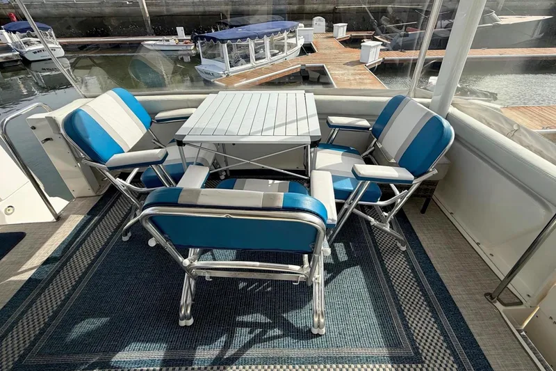 Slide: The Image of 1999 Silverton 392 Motor Yacht deck with blue and white seating and table setup. - 28