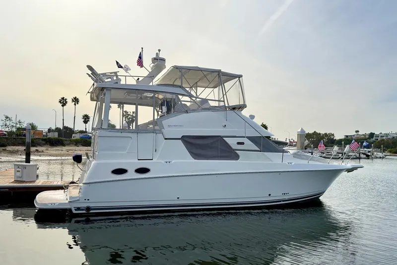 Slide: The Image of 1999 Silverton 392 Motor Yacht docked, featuring sleek design and American flags. - 3