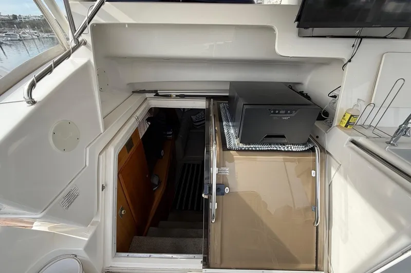 Slide: The Image of 1999 Silverton 392 Motor Yacht interior with stairs, printer, and marina view. - 30