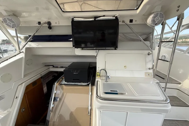 Slide: The Image of 1999 Silverton 392 Motor Yacht interior with TV, sink, and seating area. - 31