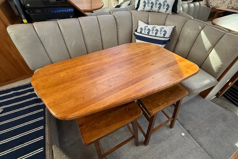 Slide: The Image of Interior of 1999 Silverton 392 Motor Yacht with wooden table and cushioned seating. - 38