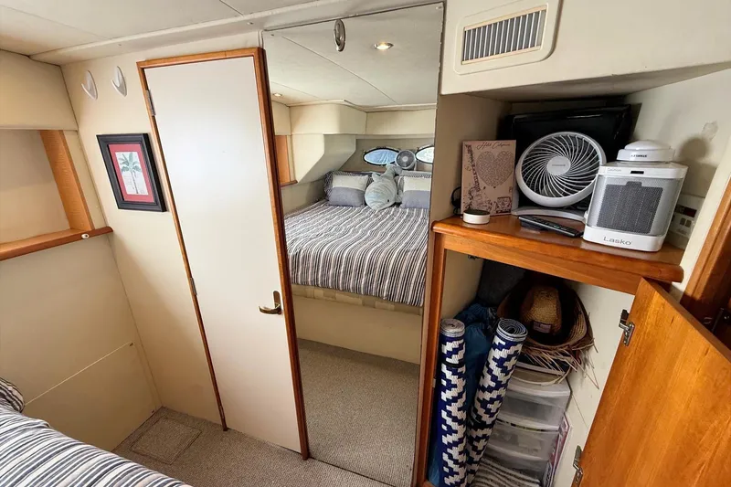 Slide: The Image of Interior of 1999 Silverton 392 Motor Yacht with cozy bedroom and storage area. - 46