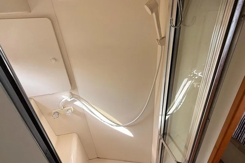 Slide: The Image of Shower area inside a 1999 Silverton 392 Motor Yacht, featuring a handheld showerhead. - 48
