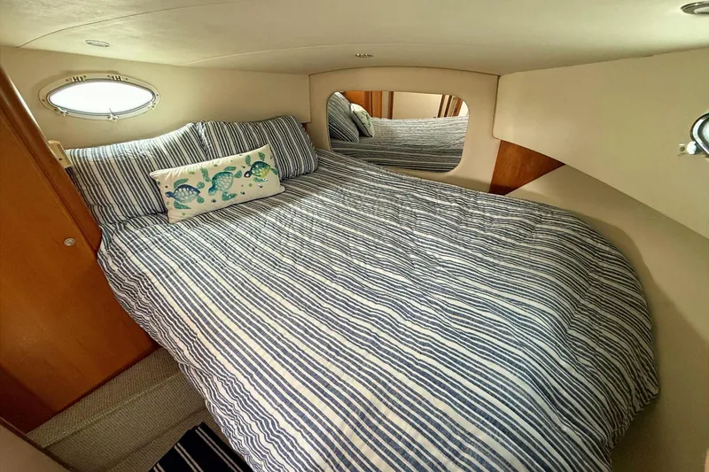 Slide: The Image of Cozy bedroom in 1999 Silverton 392 Motor Yacht with striped bedding and nautical decor. - 49