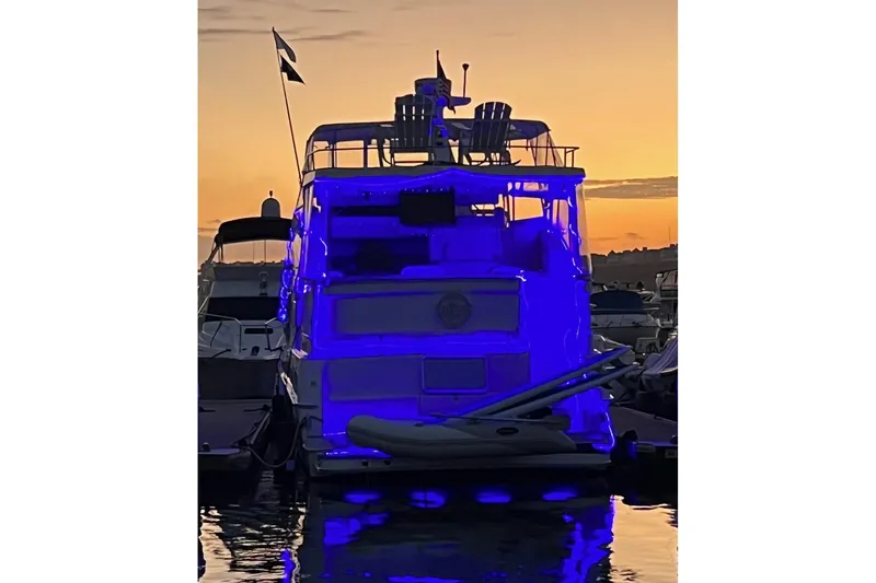Slide: The Image of 1999 Silverton 392 Motor Yacht illuminated in blue at sunset, docked in a marina. - 5