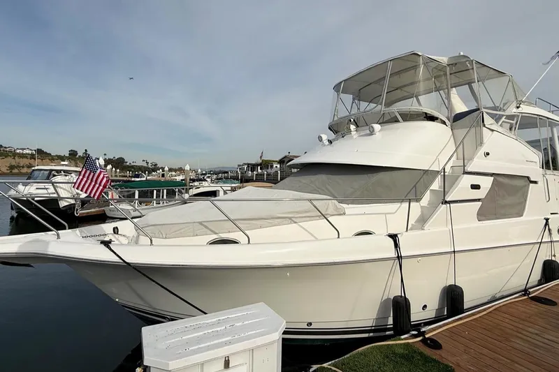 Slide: The Image of 1999 Silverton 392 Motor Yacht docked at marina with American flag. - 7