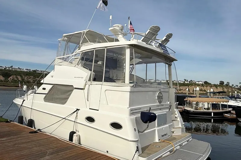 Slide: The Image of 1999 Silverton 392 Motor Yacht docked at a marina, showcasing its elegant design. - 9