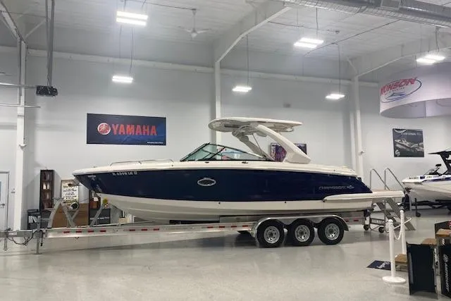 The Image of 2023 Chaparral 307 SSX boat on trailer in showroom with Yamaha signage. - 1