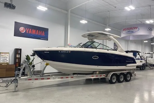 Slide: The Image of 2023 Chaparral 307 SSX boat on trailer in showroom, Yamaha banner above. - 11