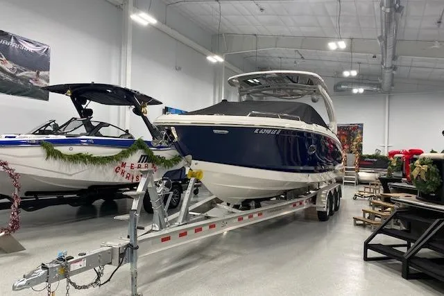 Slide: The Image of 2023 Chaparral 307 SSX boat in showroom, on trailer, with holiday decorations. - 13