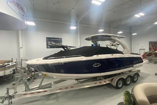 Slide: The Image of 2023 Chaparral 307 SSX boat on trailer in showroom, covered and ready for display. - 15