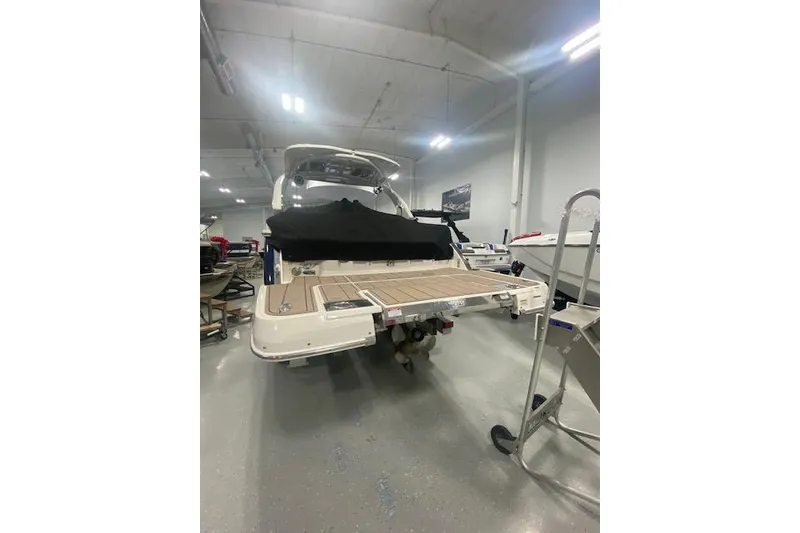 Slide: The Image of 2023 Chaparral 307 SSX boat in showroom, rear view with covered deck. - 16