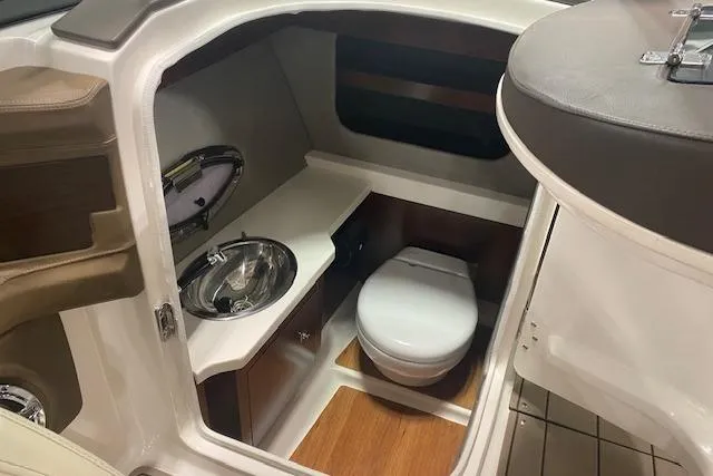 Slide: The Image of 2023 Chaparral 307 SSX boat interior with sink and toilet in compact cabin. - 29