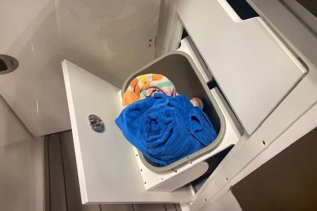 Slide: The Image of Storage compartment with towels in 2023 Chaparral 307 SSX boat. - 32