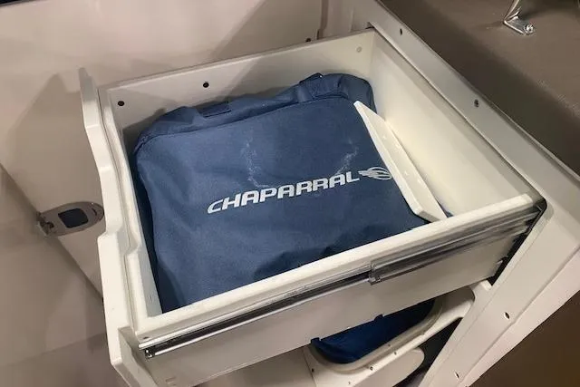Slide: The Image of 2023 Chaparral 307 SSX boat storage drawer with branded blue bag. - 33