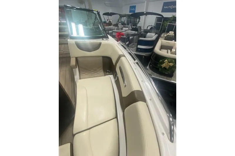 Slide: The Image of 2023 Chaparral 307 SSX boat interior with beige seating in showroom. - 36