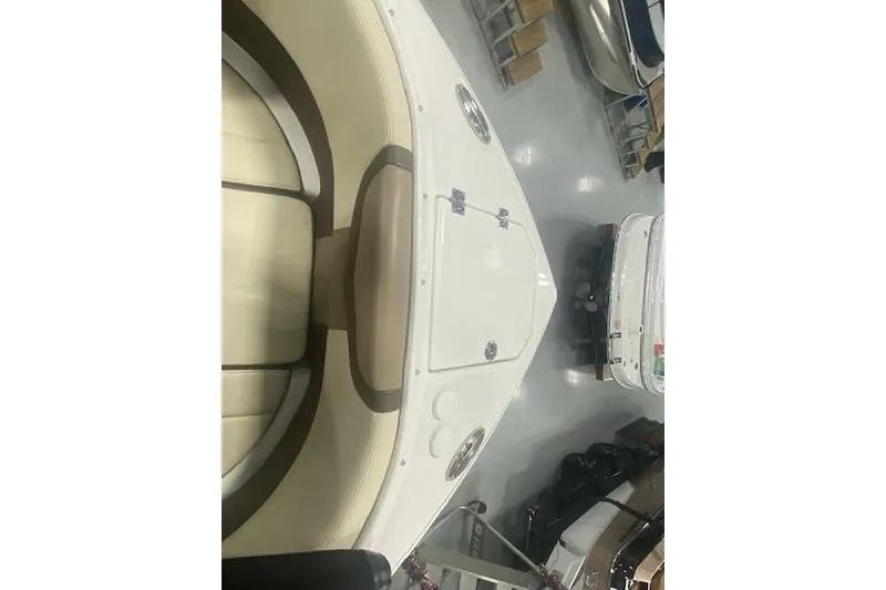 Slide: The Image of 2023 Chaparral 307 SSX boat interior with beige seating and storage compartment. - 38