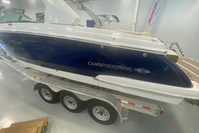 Slide: The Image of 2023 Chaparral 307 SSX boat on a triple-axle trailer in showroom. - 4