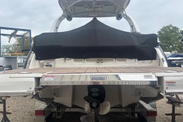 Slide: The Image of 2023 Chaparral 307 SSX boat rear view with covered deck and dual propellers. - 45