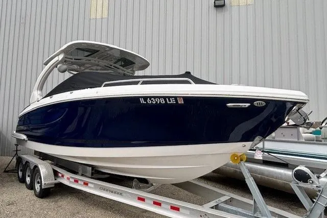 Slide: The Image of 2023 Chaparral 307 SSX boat on trailer, blue hull, parked outdoors. - 46