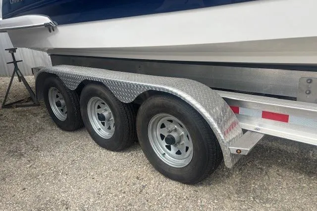 Slide: The Image of Trailer for 2023 Chaparral 307 SSX boat with triple axles on gravel. - 53