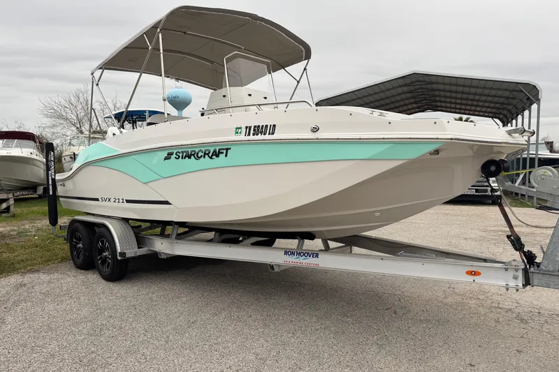 The Image of 2024 Starcraft SVX 211 OB boat on trailer, parked outdoors. - 0