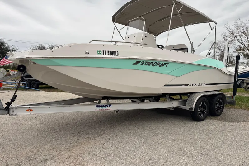 Slide: The Image of 2024 Starcraft SVX 211 OB boat on trailer, featuring sleek design and mint green accents. - 1