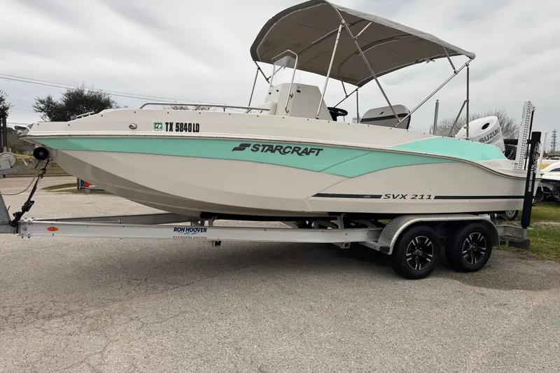 Slide: The Image of 2024 Starcraft SVX 211 OB boat on trailer, featuring a sleek design and canopy. - 11