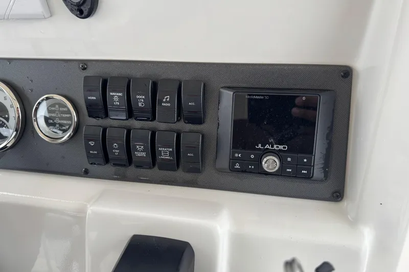 Slide: The Image of 2024 Starcraft SVX 211 OB boat dashboard with JL Audio system and control switches. - 9
